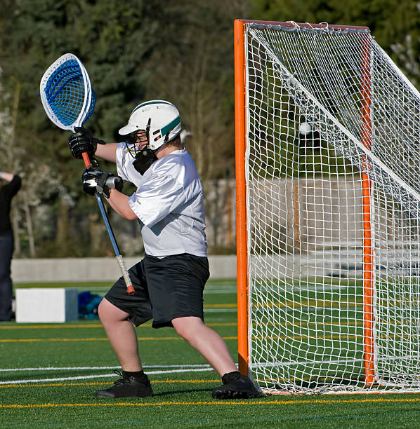 Lacrosse goalie, one gets by. A boys high school lacrosse goalie lets one get by. teen goalie stock pictures, royalty-free photos & images