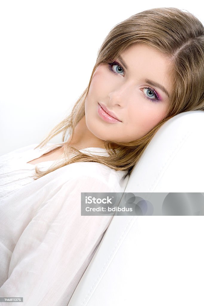 Portrait of beautiful young woman on sofa Portrait of a smiling beautiful young woman sitting on sofa in house Adult Stock Photo