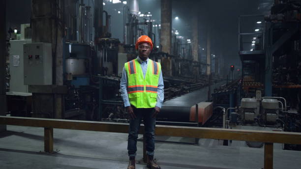 istock Happy supervisor smiling camera wearing safety uniform at modern facility. 1468115864