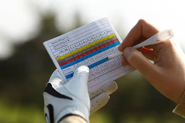 Writing golf handicap with a glove.