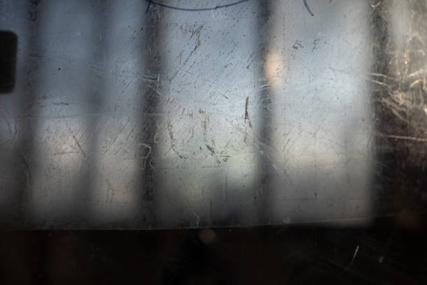 Scratched surface. Scratches on glass. Texture transparent in small strokes. Blurry background outside window.