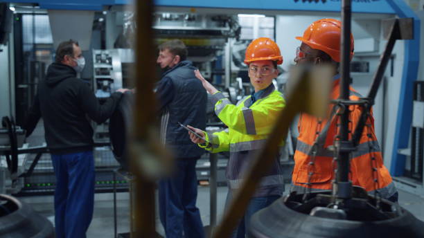 istock Focused colleagues discussing project work at huge modern special factory. 1468121112