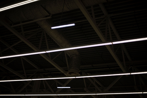 Lights on ceiling. Light in stock. Interior details of industrial building. Fluorescent lamps.