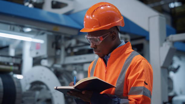 istock Uniformed engineer writing notes at machinery plant. Closeup analyst concept 1468123382