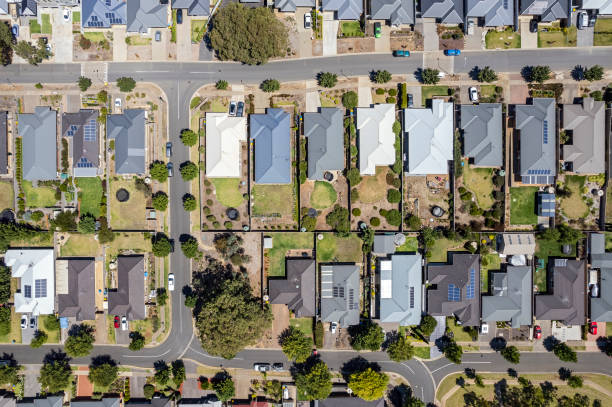 istock Aerial view new rural housing development, mostly grey roofing, some green landscaping, trees, unusual road design 1468128062