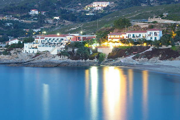 Greek village by night A beautiful Greek village by night and the reflection in the Aegean sea ikaria island stock pictures, royalty-free photos & images