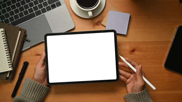 istock Creative woman hands holding digital tablet with white empty display over wooden working desk. 1468132712