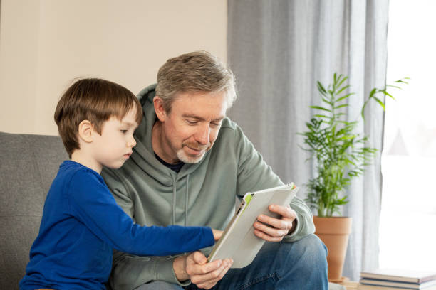 istock White 50 year old man playing video game with his son using digital tablet 1468133919