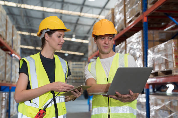istock Male and female warehouse workers working with laptop computer in the storage warehouse. Team of warehouse workers using ipad tablet and computer discuss and training work in distribution branch 1468135045