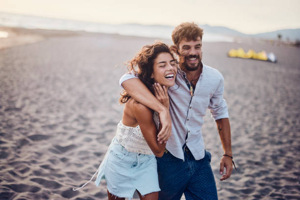 istock Happy couple walking embraced on the beach. 1468135651