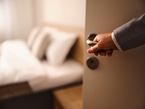 Close up of unrecognizable businesswoman entering the hotel room. Photographed in medium format.