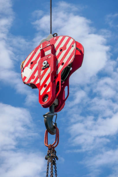 Red and White Block Hoist Chain block hoist with the steel cable attached to a crane on construction site in Bondi Junction, Sydney.  This image was taken on a sunny morning in late summer. bondi junction stock pictures, royalty-free photos & images