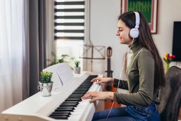 adolescente caucásica, músico, tocando el piano. - young women sitting simple living eastern europe fotografías e imágenes de stock