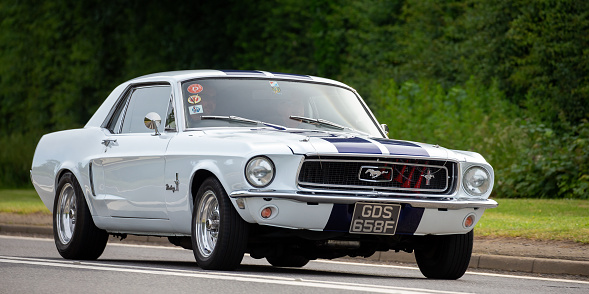 Bicester,Oxon,UK - June 19th 2022. 1969 Ford Mustang driving on an English country road