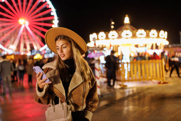 istock Beautiful young woman texting on smart phone at amusement park 1468147741