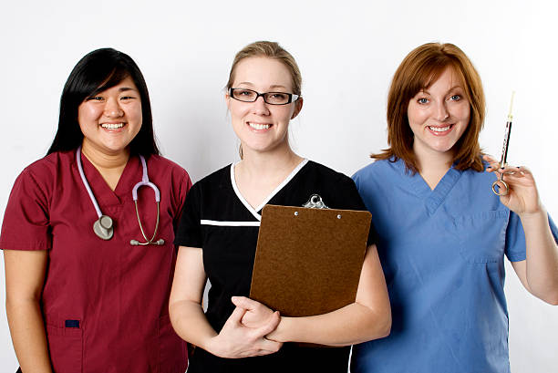 Cheerful Group of Medical Professionals Diverse Group of Medical Professionals with various medical instruments on a white background red medical scrubs stock pictures, royalty-free photos & images