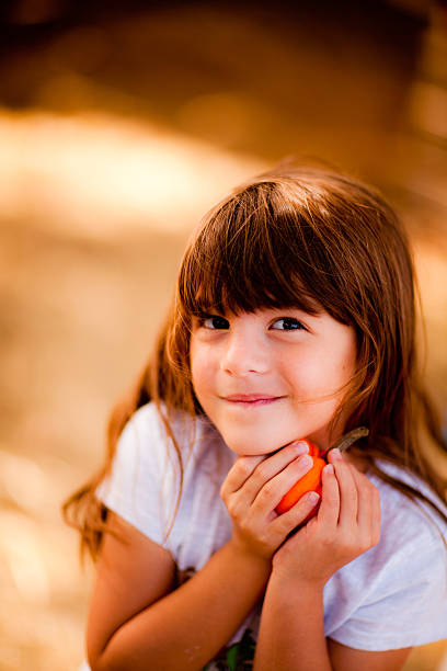 Young Girl holding Pumpkin during Harvest Time stock photo