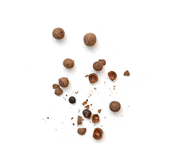 mix of whole and broken pieces of black pepper, peppercorns or allspice isolated on white, top view - pepper imagens e fotografias de stock