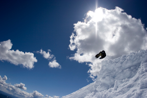 Snowboarder hitting a back country jump built in Oregon.