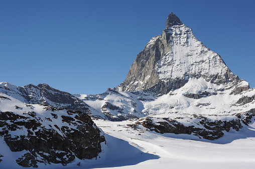 Matterhorn mountain peak  in Alps in winter with snow and clear blue sky in Cervinia, Italy and Zermatt, Switzerland. Beautiful and magnificent landscape on a sunny day in Europe