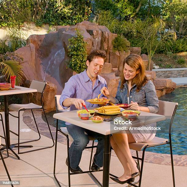 Young Couple By The Side Of Pool Stock Photo - Download Image Now - Couple - Relationship, Eating, Mexican Food