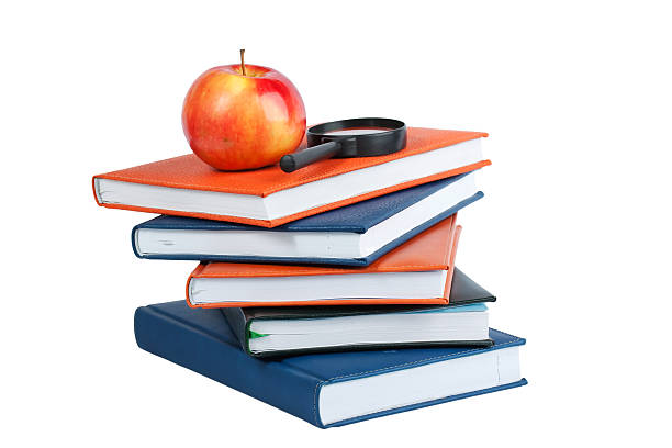 istock Magnifying glass and red apple on stack of books 146815796