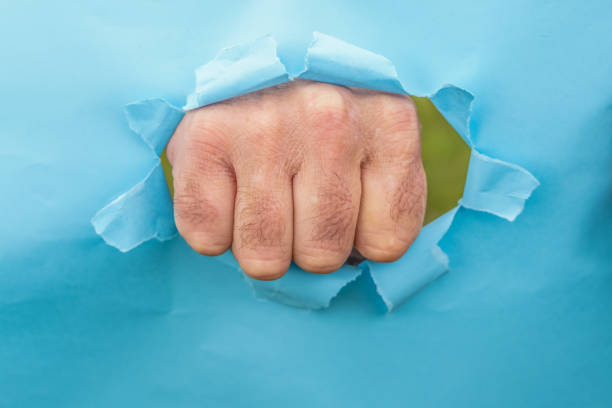 istock man's fist breaking a cardboard 1468161937