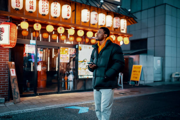 Mid adult man exploring Japanese night life stock photo
