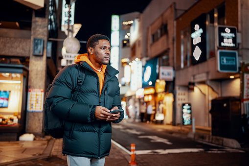 Mid adult man exploring Japanese night life in Okayama City, Japan