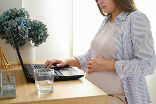 istock Beautiful young pregnant woman working on a laptop while sitting at a table 1468165912