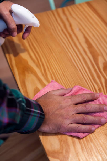istock person cleaning a table with a rag and a spray 1468168055