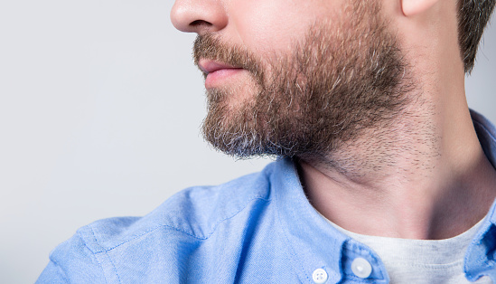 cropped closeup of bearded man with beard wearing casual shirt. bearded man with beard isolated on grey background. bearded man with beard in studio. photo of bearded man with beard.