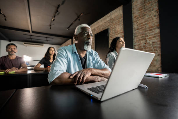 istock Senior man using laptop and listening during a presentation 1468169627