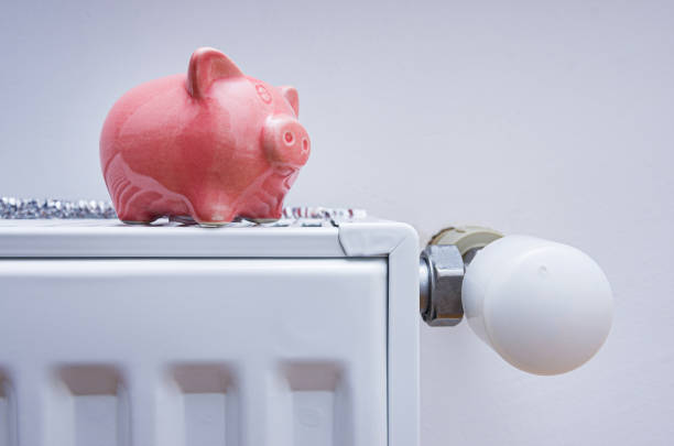 istock Piggy bank on the radiator heating. 1468170715