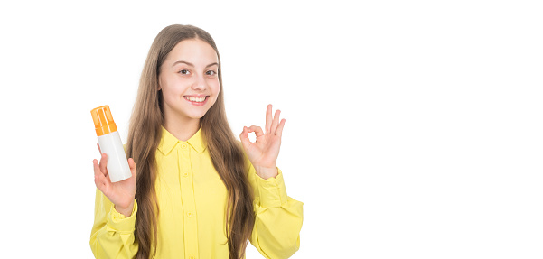 happy kid presenting shampoo or hair body conditioner bottle show ok gesture isolated on white copy space, ad.