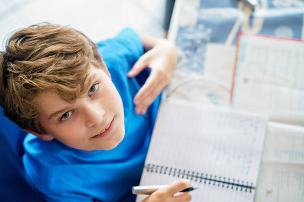 istock Young boy doing his homework at home. School kid learning. 1468173769