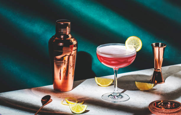 진, 석류 시럽, 레몬 주스 및 달걀 흰자, 짙은 녹색 배경, 밝고 단단한 빛과 그림자 패턴이 있는 핑크 레이디 알코올 칵테일 음료 - dry vermouth 뉴스 사진 이미지