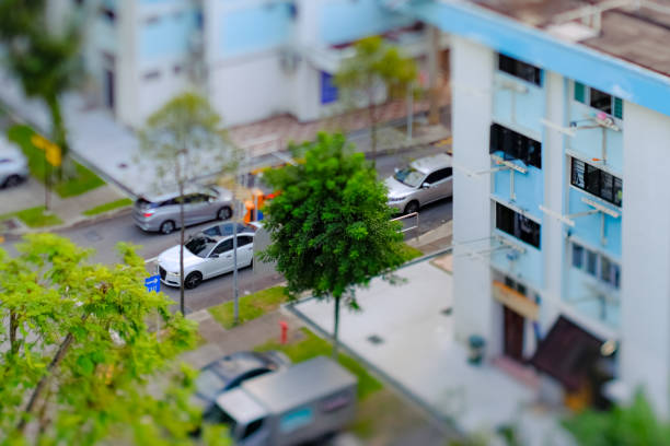 tilt-shift-objektivfotografie; miniatureffekt – luftaufnahme des hdb heartland estate viertels in singapur; selektiver fokus. autos, die in öffentliche parkplätze ein- und ausfahren - tilt shift lens stock-fotos und bilder