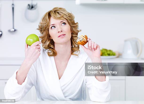 Woman Choosing Between Healthy Food And Caloric Cake Stock Photo - Download Image Now