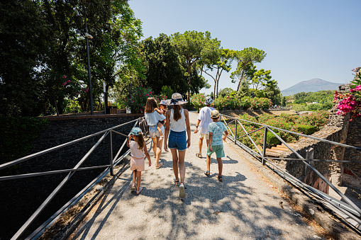 Family tourist walking at garden of Pompeii ancient city, Italy.