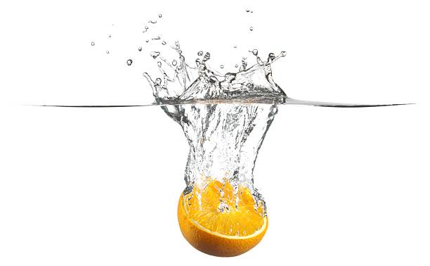 Half Orange Fruit falling into water splash stock photo