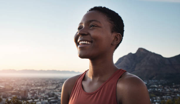 les montagnes, le fitness et la femme noire sourient pour le succès de l’entraînement, les objectifs de bien-être et les réalisations en plein air sur une maquette de ciel bleu. coureur du matin, sportif ou athlète dans la nature avec paysage urbain - black forest forest sky blue photos et images de collection