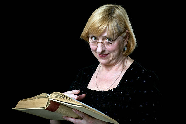 feliz mulher idosa com livro e óculos sobre preto - 65 70 age imagens e fotografias de stock