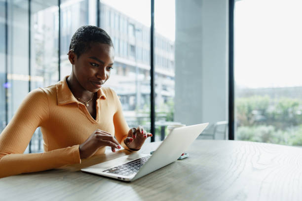 istock Young african woman freelancer working on laptop while sitting in coworking 1468184982