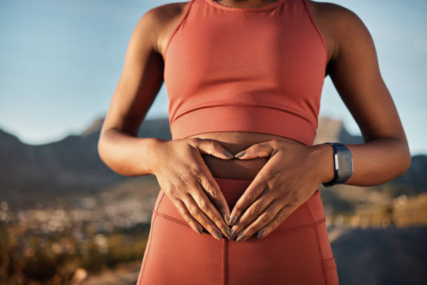 woman, nature fitness or hands on stomach in diet wellness, body healthcare or abs muscle growth in workout training or sunrise exercise. zoom, sports athlete or person, belly digestion or strong gut - buik stockfoto's en -beelden