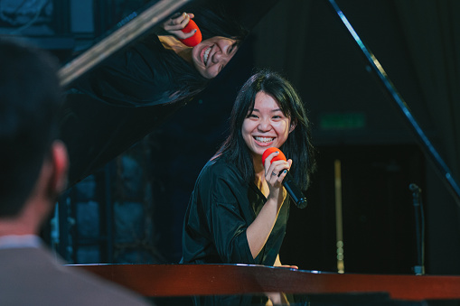 Asian Chinese young Female opera singer enjoy practising solo on stage with pianist
