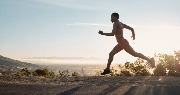 Black woman, fitness and running on mountain during sunset for workout, training or exercise in the nature outdoors. African American woman runner in sport exercising for healthy cardio on mockup mujer negra, fitness y correr en la montaña durante la puesta de sol para hacer ejercicio, entrenamiento o ejercicio en la naturaleza al aire libre. corredora afroamericana en el deporte haciendo ejercicio para cardio saludable en maqueta