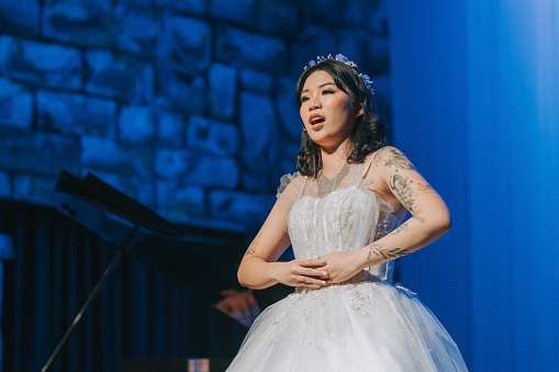 Young Chinese Female opera singer performing solo on stage
