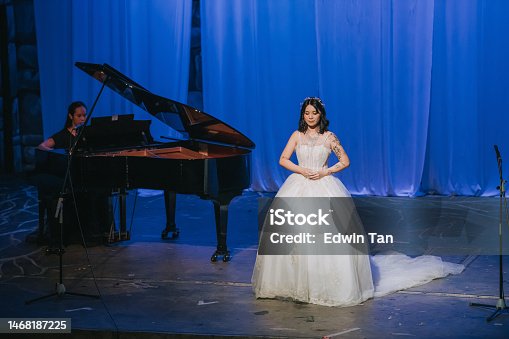 istock Young Chinese Female opera singer performing solo on stage with pianist 1468187225