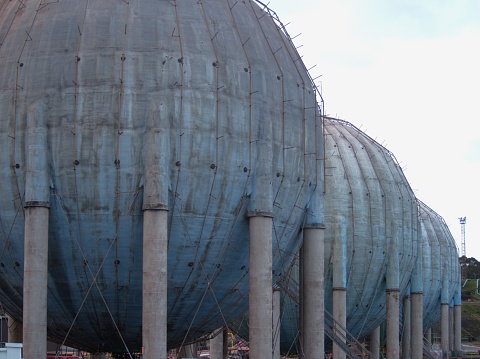 Large row of ball-shaped gas and liquid storage tanks on an industrial site